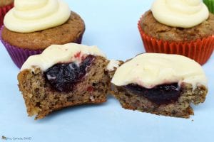 Raspberry Banana Cake Cupcakes with Cream Cheese Icing chopped in half with the raspberry jam filling.