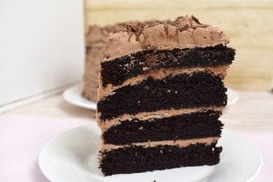 Nutella Chocolate Cake is a dense and fluffy chocolate mud cake with a creamy Nutella Buttercream filling and topping and finished with Nutella drizzled overtop. #nutellacake #nutellachocolatecake #chocolatecake #bestchocolatecake #nutellalayercake