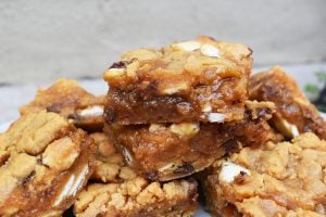 Caramel Peanut Butter Slice is a gooey, chewy, buttery and oh-so-delicious peanut butter cookie bar stuffed with caramel sauce and speckled with white chocolate and chocolate chips. #peanutbuttercookeis #caramelcookiebars #caramelcookiebars #peanutbuttercaramelslice #caramelslice #cookiebars