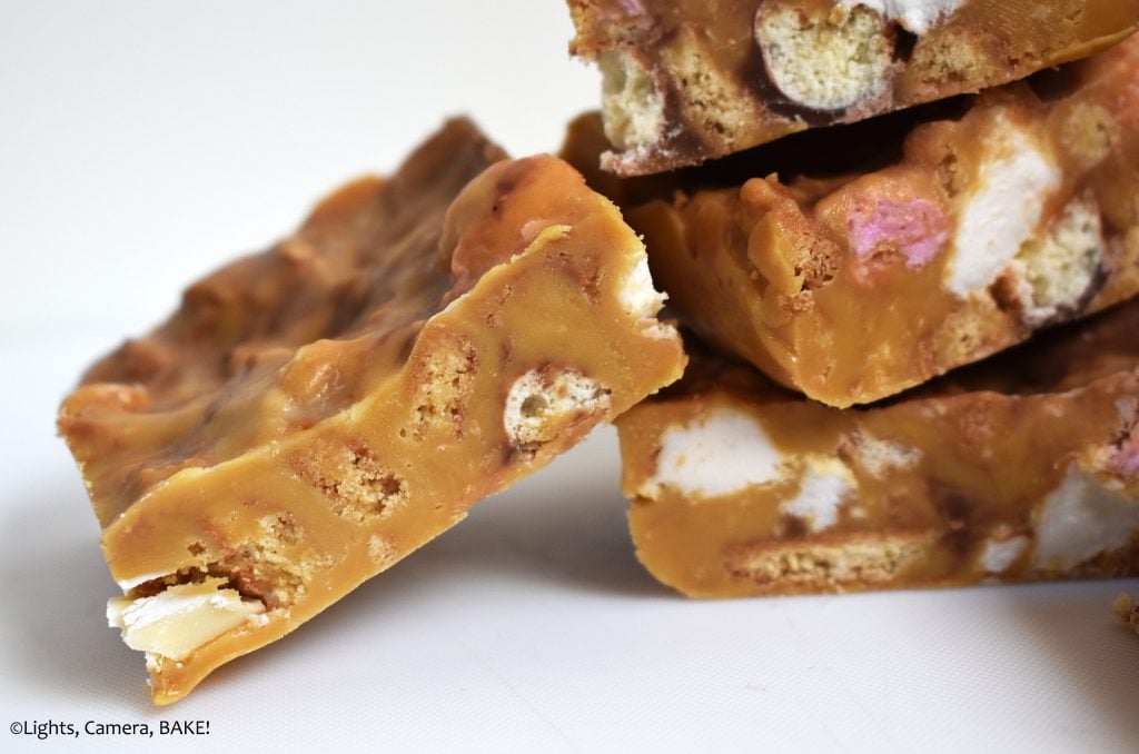 Close up of a piece of Caramilk rocky road on a white background